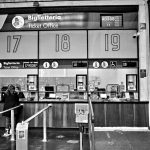 Guichês numerados de atendimento em uma estação ferroviária, onde passageiros podem buscar informações ou registrar reclamações.
