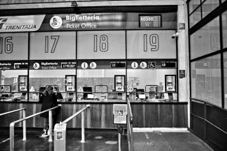 Guichês numerados de atendimento em uma estação ferroviária, onde passageiros podem buscar informações ou registrar reclamações.
