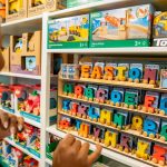 Mulher escolhe brinquedos educativos coloridos em uma loja infantil.